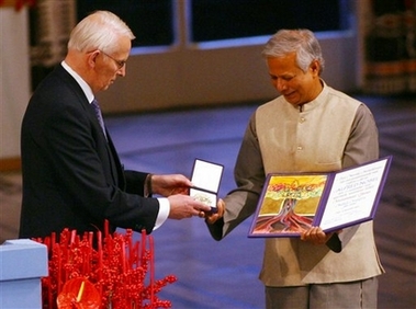 Nobel Peace Prize winner Muhammad Yunus, right, receives his medal and diploma from Nobel Committee Chairman Ole Danbolt Mjoes at City Hall in Oslo, Norway Sunday Dec. 10, 2006. Yunus said he hoped the award would inspire 'bold initiatives' to fight poverty and eradicate the root causes of terrorism. (AP