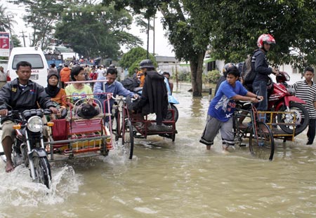 Passengers ride pedicabs through a flooded street in the district of Langkat in North Sumatra province December 24, 2006. Floods in Indonesia's Aceh and North Sumatra province have left at least 22 people dead and six missing, Health Ministry official Rustam Pakaya said on Sunday.