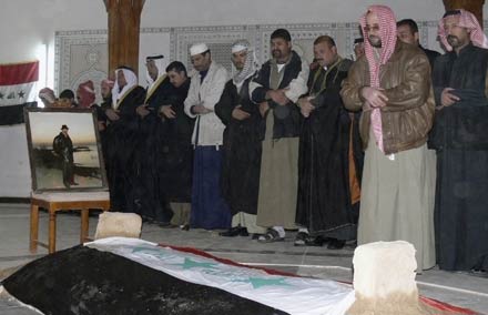 Men pray over the coffin of Iraq's former president Saddam Hussein during a funeral in Awja, near Tikrit in northern Iraq, 175 km (110 miles) north of Baghdad, December 31, 2006. Saddam Hussein was buried before dawn on Sunday in his native village of Awja, the head of his tribe said. REUTERS/Nuhad Hussin(IRAQ)