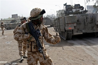 British army soldiers take defensive positions after their convoy was struck by a roadside bomb in Basra, 550 kilometers (340 miles) southeast of Baghdad, Iraq, Saturday, Jan. 6, 2007. A roadside bomb targeted a British army convoy and wounded one soldier, whose wounds were not considered to be life-threatening, the British army said. (AP Photo/Nabil al-Jurani) 