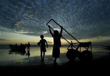 Children play with a cart as the sun sets on La Boquita's beach, about 45 km (57 miles) south of Managua February 9, 2007