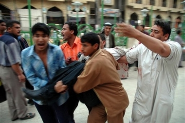An injured man is carried away following an explosion in a crowded commercial area near the Imam Hussein shrine in Karbala, 80 kilometers (50 miles) south of Baghdad, Saturday, April 28, 2007