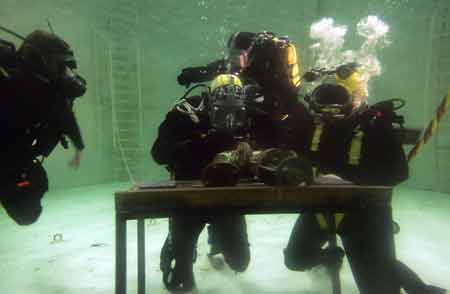 Britain's Prince Harry (C) carries out some underwater engineering during his visit to the Royal Navy's fleet diving squadron at Horsea Island in Portsmouth, southern England, Oct. 31, 2007. It was Prince Harry's first official visit since becoming Commodore-in-Chief of small ships and diving.