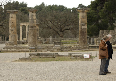 A couple stand in front of the temple of the Hera inside ancient Olympia's archaeological site February 11, 2008. Workers are racing against the clock to re-plant trees on ancient Olympia before next month's Beijing Games torch-lighting ceremony after the area was devastated by last year's forest fires.