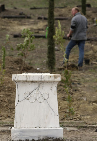 A worker plants cypress trees behind an altar at the Pierre de Coubertin monument in ancient Olympia February 11, 2008. Workers are racing against the clock to re-plant trees on ancient Olympia before next month's Beijing Games torch-lighting ceremony after the area was devastated by last year's forest fires. [Agencies]