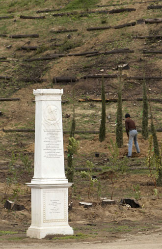 A worker plants cypress trees behind the Pierre de Coubertin monument in ancient Olympia February 11, 2008. Workers are racing against the clock to re-plant trees on ancient Olympia before next month's Beijing Games torch-lighting ceremony after the area was devastated by last year's forest fires. [Agencies]