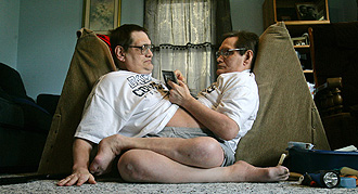 Oldest conjoined twins will live with younger brother