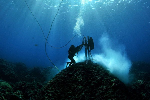 Divers inspect coral on the Great Barrier Reef