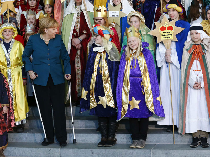 Merkel meets carols singers with crutches