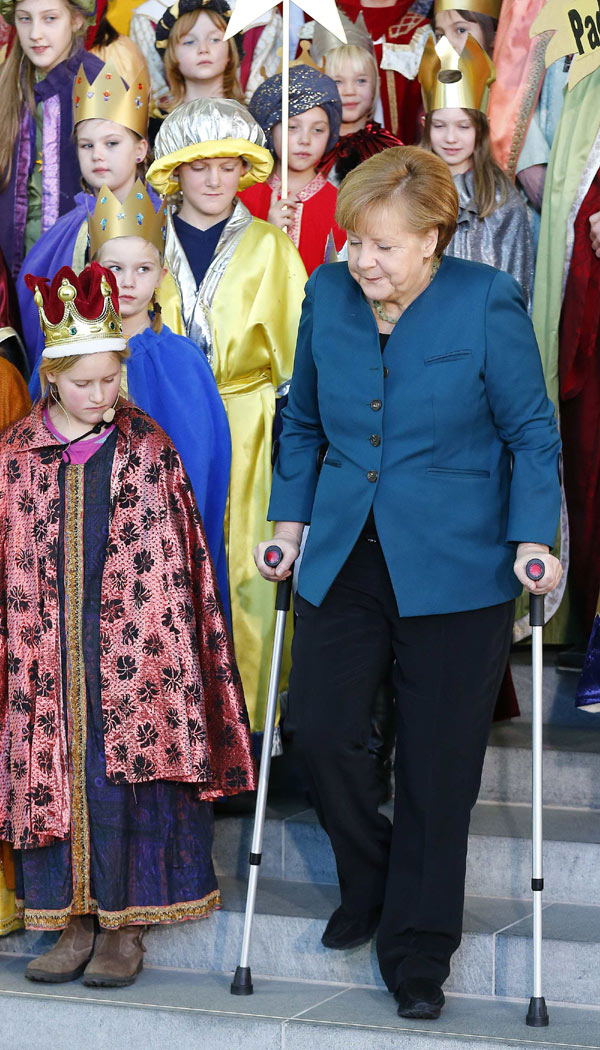 Merkel meets carols singers with crutches