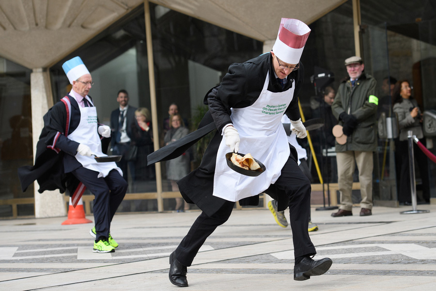 In costume, Londoners flip pancakes in annual race